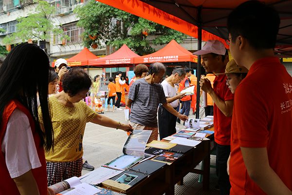 (社区居民翻阅学院《公益摄影—乡土潮汕百村行》课程的优秀作品)