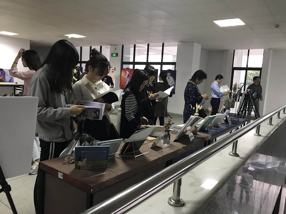 (学生正在作品展上翻看作品 卢星霏摄)
